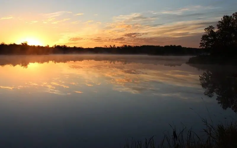 Sunrise reflecting on the calm waters of Turtle Mountains.
