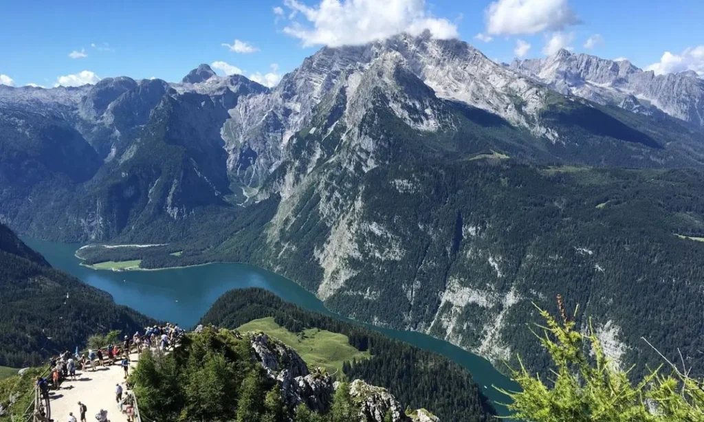 Panoramic mountain and lake view from Berchtesgaden with people at a lookout.