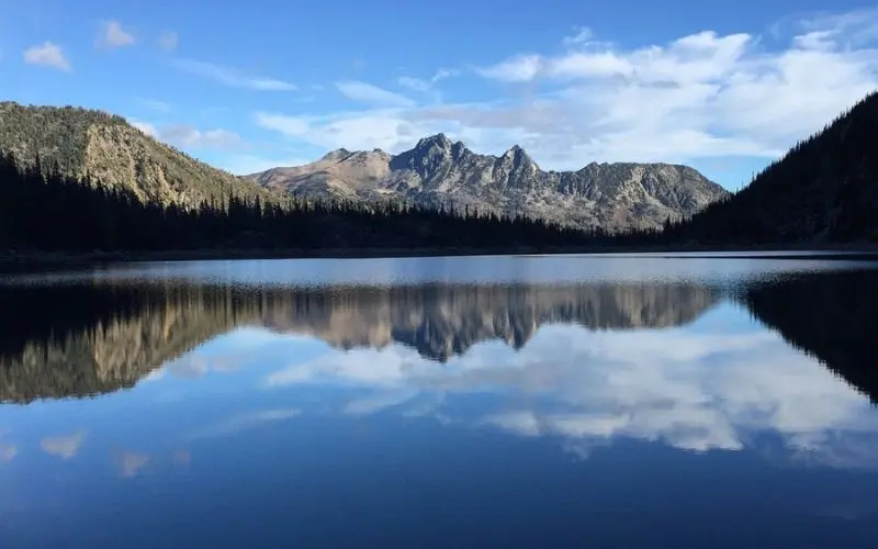 Clear lake reflecting rugged mountain peaks at Enchantment Lakes.