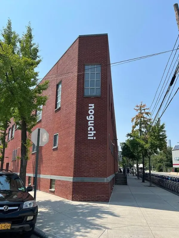 The brick building of the Noguchi Museum has its name displayed vertically on the corner.