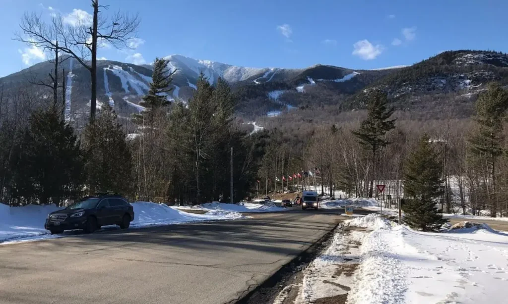 Snowy ski trails cover the slopes of Whiteface Mountain under a clear blue sky.