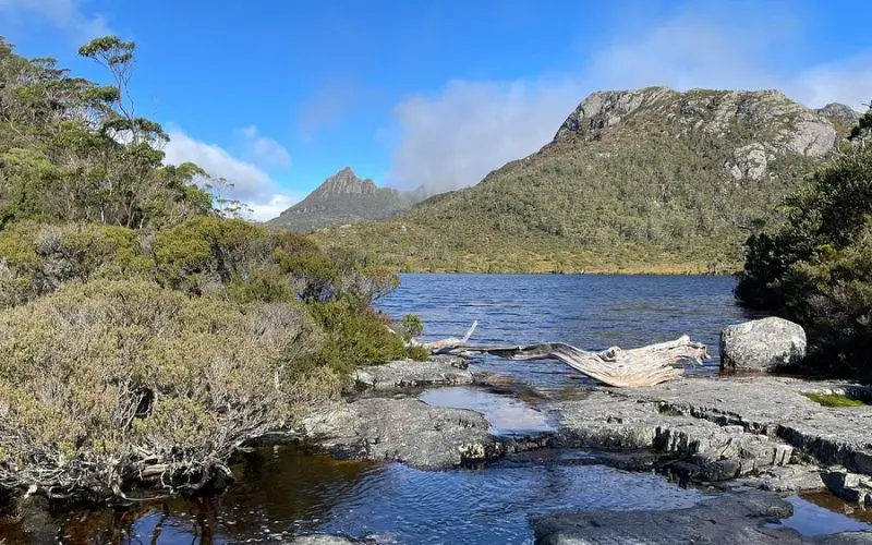 Tranquil lake with mountain peaks in the background at Cradle Mountain-Lake St Clair National Park.