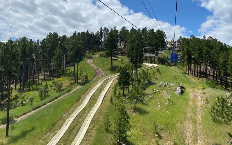 A scenic alpine slide and chairlift at Rushmore Tramway Adventures.