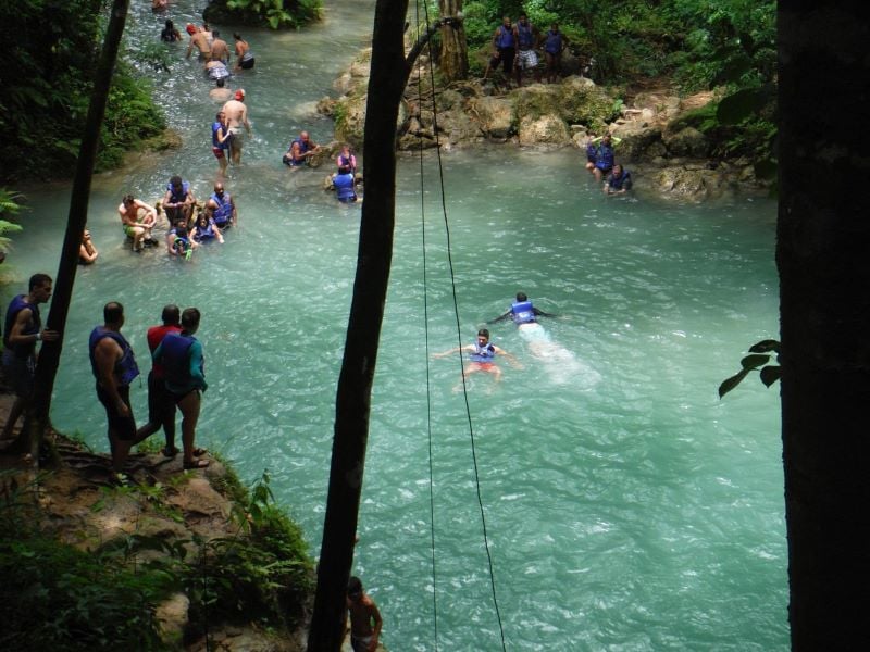 Tourists snorkeling and diving in the crystal-clear waters of the Blue Hole, revealing the magical underwater world beneath