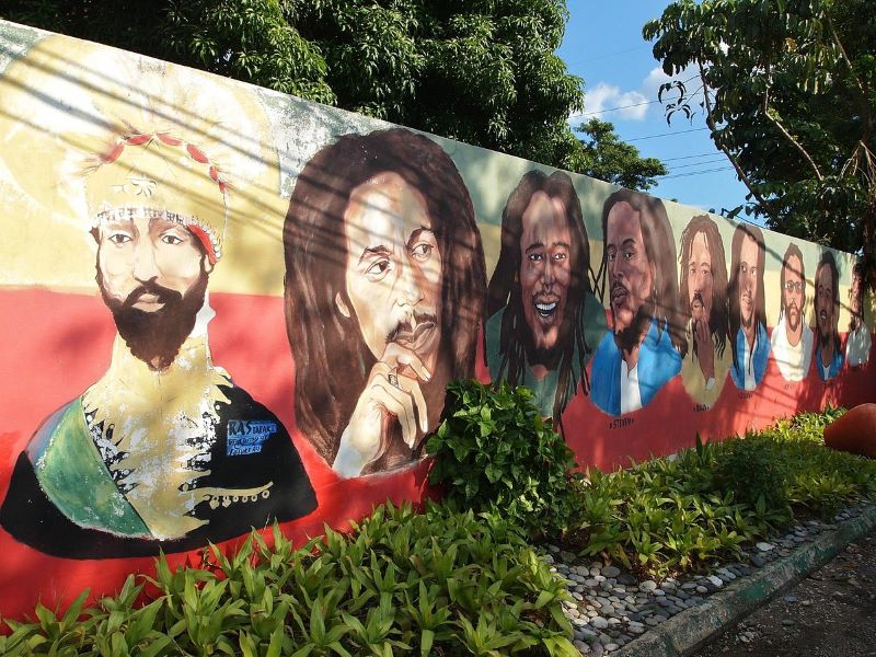 Exterior view of the Bob Marley Museum, surrounded by lush gardens and colorful murals