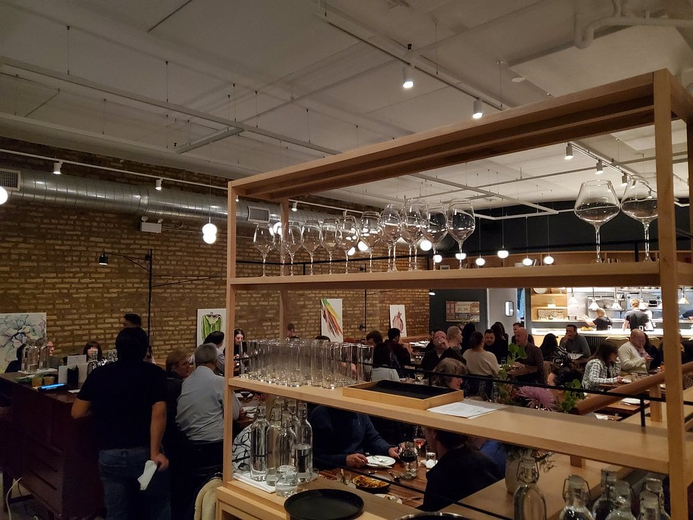 Daisies restaurant dining room filled with guests enjoying dinner in a warm, modern space.