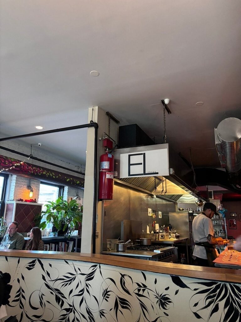 Open kitchen and casual dining space at EL ideas with modern, artistic decor.