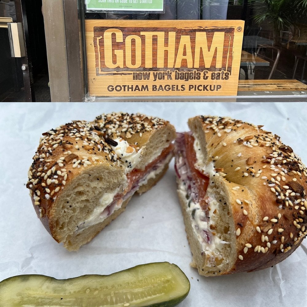 Everything bagel sandwich with cream cheese and lox from Gotham Bagels, served with a pickle slice.