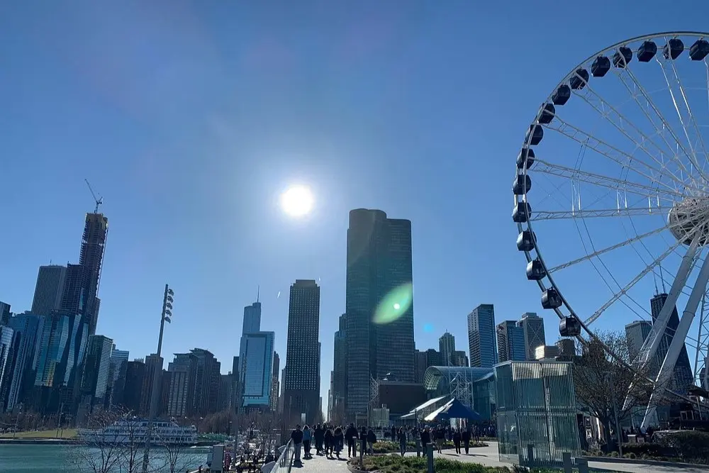 Navy Pier in Chicago with the Ferris wheel and city skyline under a clear blue sky.