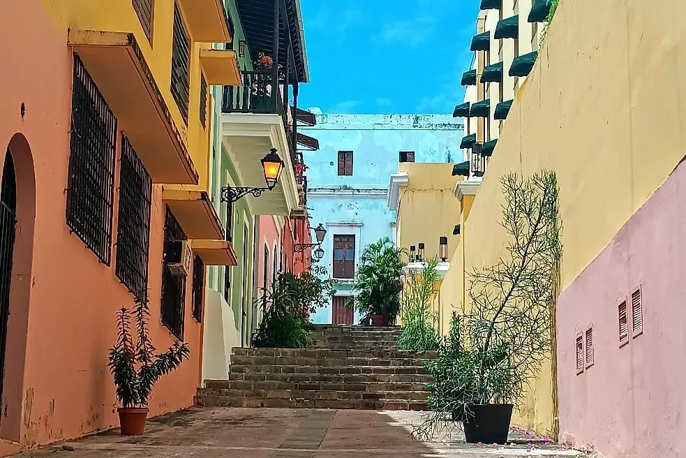 Colorful buildings line a narrow, stone street in Old San Juan, Puerto Rico.
