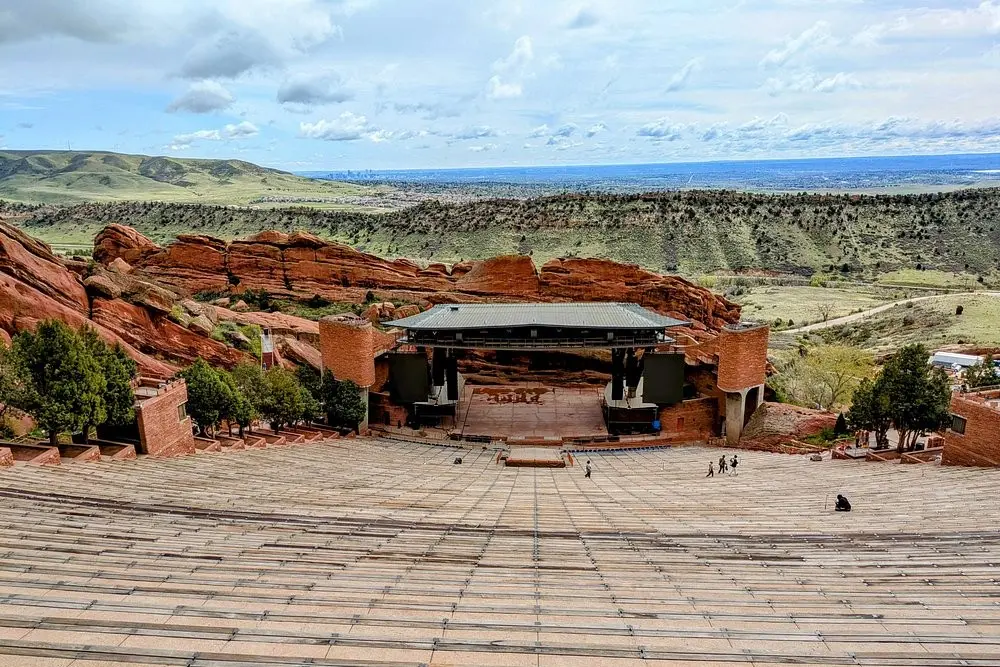 Red Rocks Park and Amphitheatre in Colorado features a large outdoor stage surrounded by red rock formations and scenic mountain views.