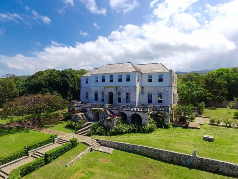 Exterior view of Rose Hall Great House, showcasing its colonial architecture against a lush backdrop