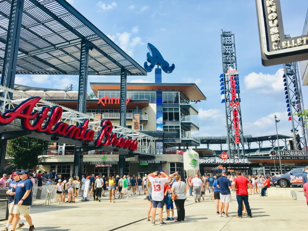 Crowds gathered outside the Atlanta Braves Truist Park stadium entrance near the Chop House Gate under a sunny sky