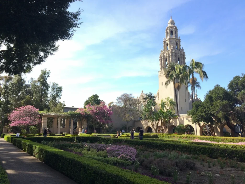 California Tower and Alcazar Garden in Balboa Park, San Diego with manicured hedges and palm trees