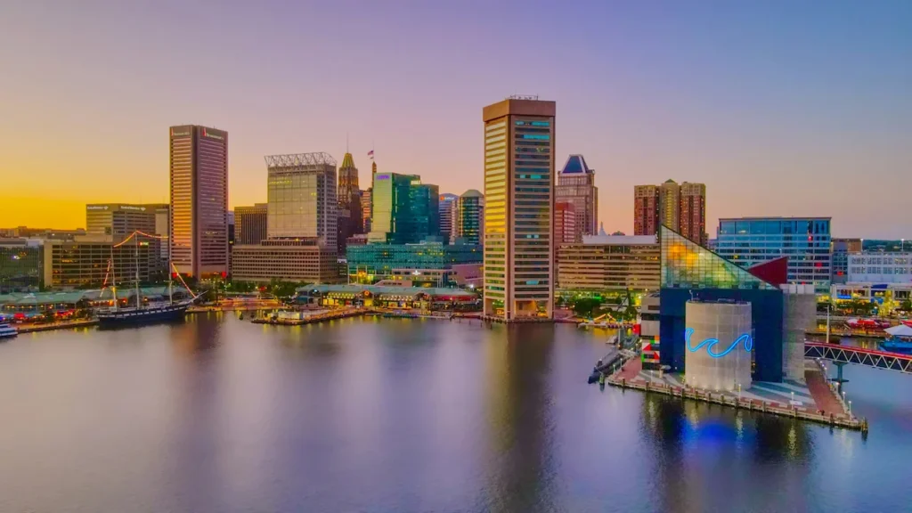 National Aquarium and downtown skyline illuminated along the Inner Harbor in Baltimore