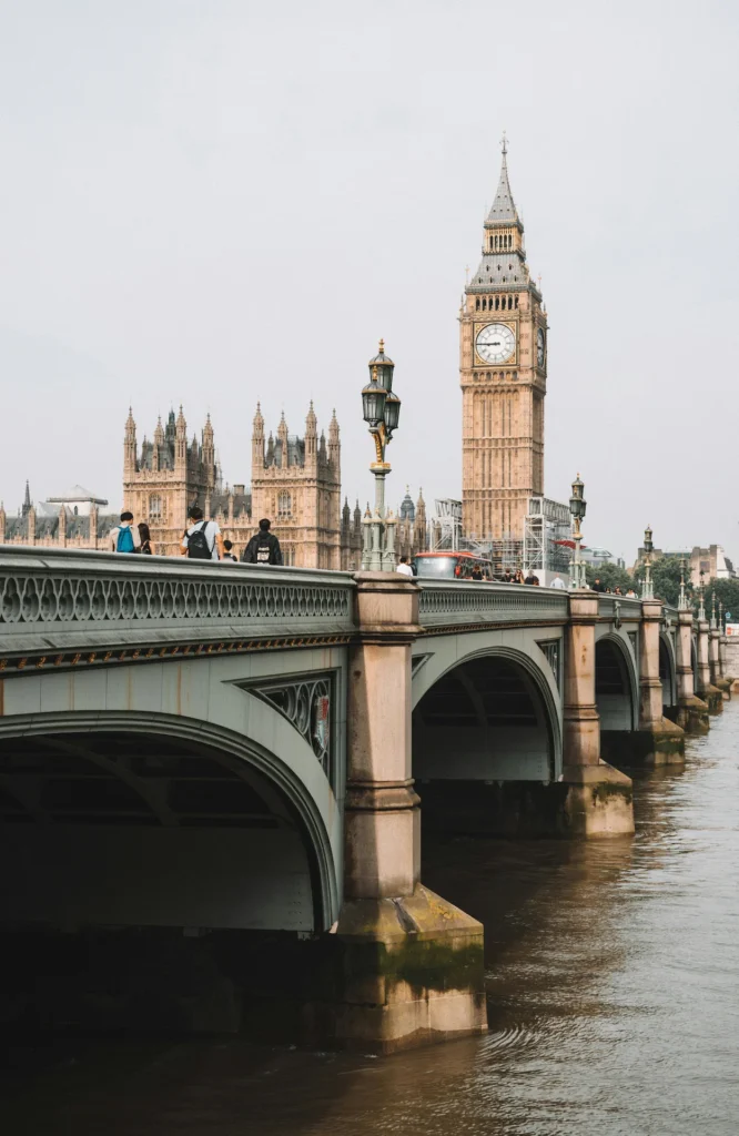 Elizabeth Tower and Big Ben rising behind the green arches of Westminster Bridge in London