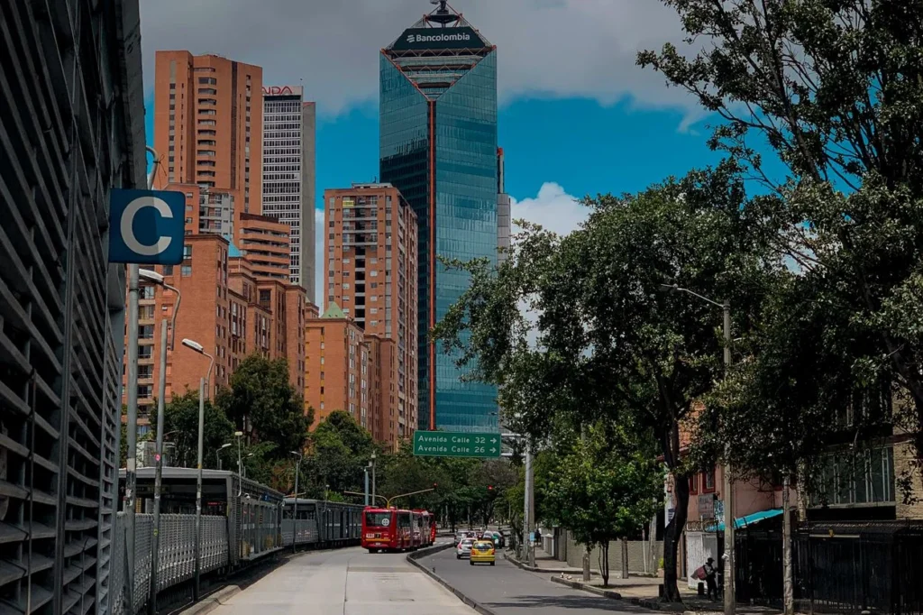 The Bancolombia tower rising over a TransMilenio bus lane in Bogotá, Colombia