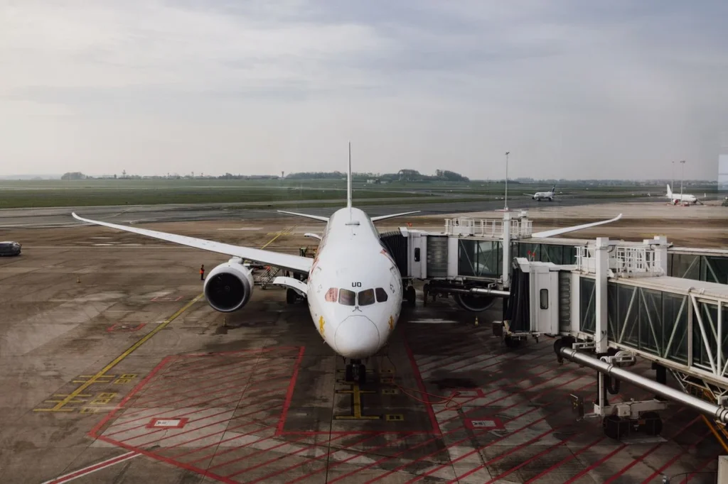 A TUI fly Belgium Boeing 787 Dreamliner parked at a jet bridge on a cloudy day