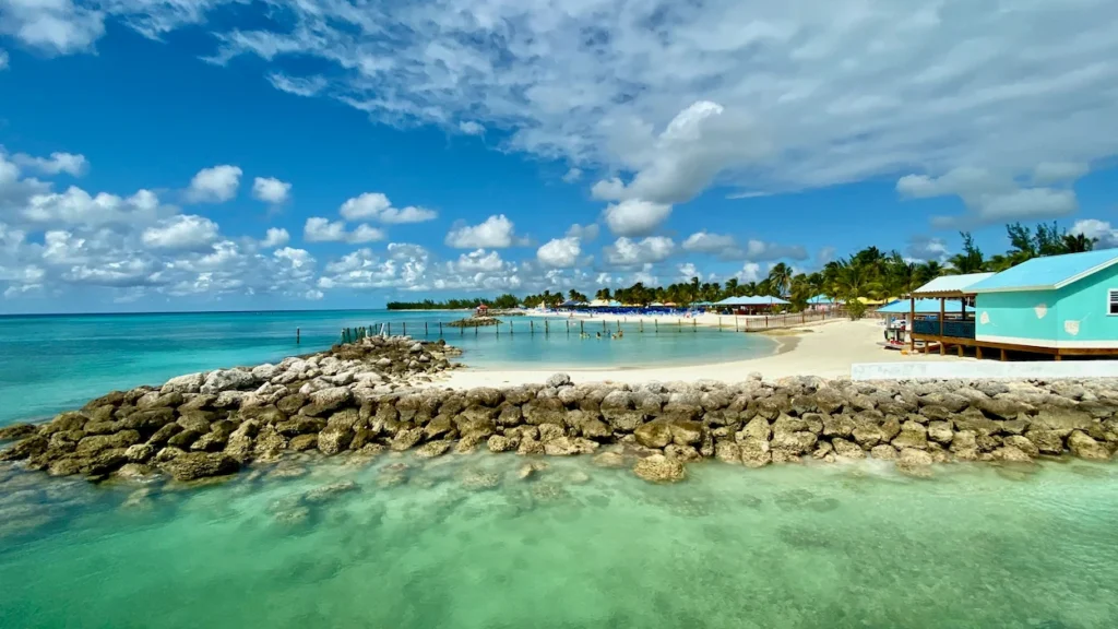 Clear turquoise lagoon and blue beach cabanas in Eleuthera, Bahamas