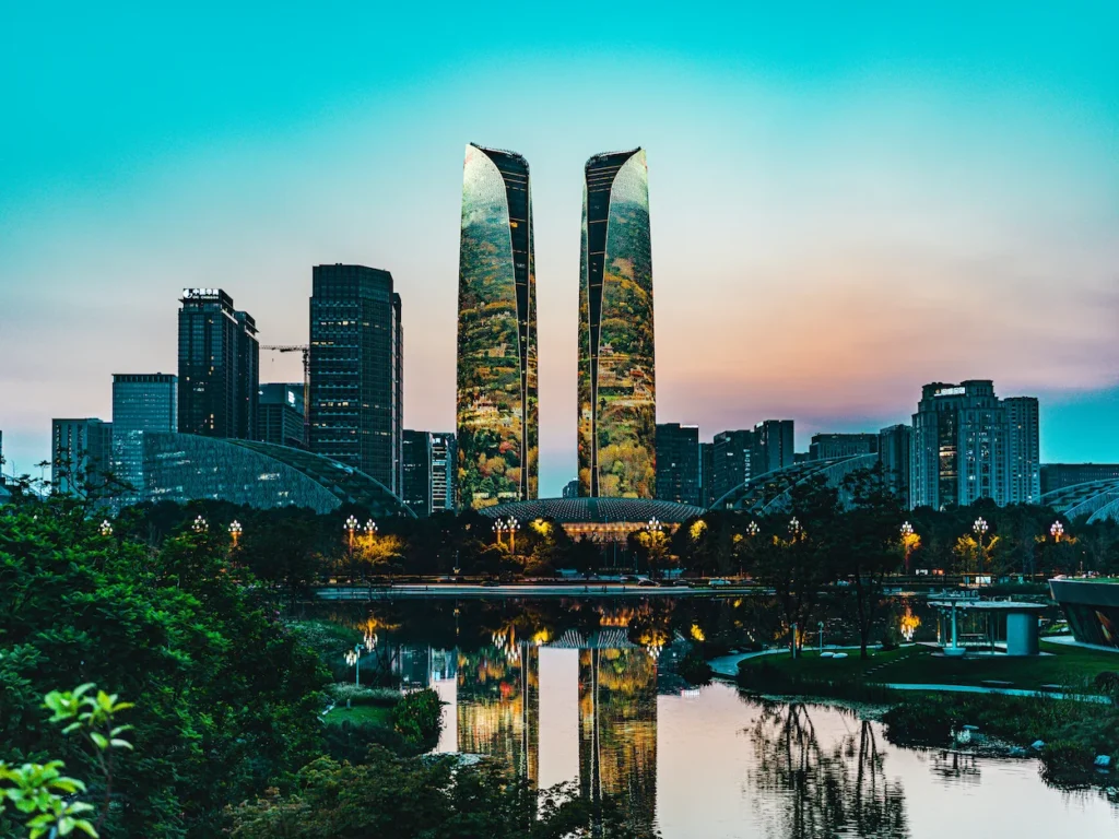 Chengdu Financial City Twin Towers illuminated with digital nature projections reflecting on water at dusk