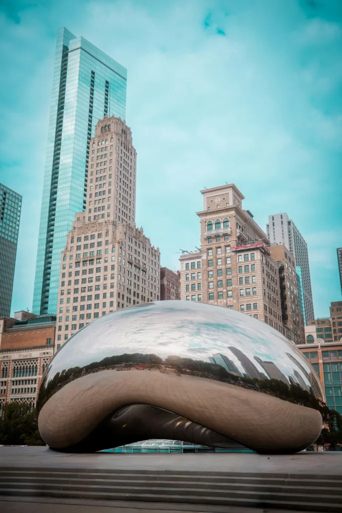 Reflective Cloud Gate sculpture with downtown skyscrapers in the background