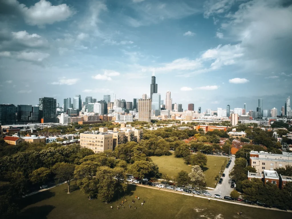 An elevated view of the Chicago skyline featuring the Willis Tower over a green park