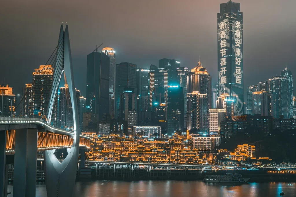 Chongqing skyline at night showing Qiansimen Bridge, Hongyadong complex, and illuminated skyscrapers
