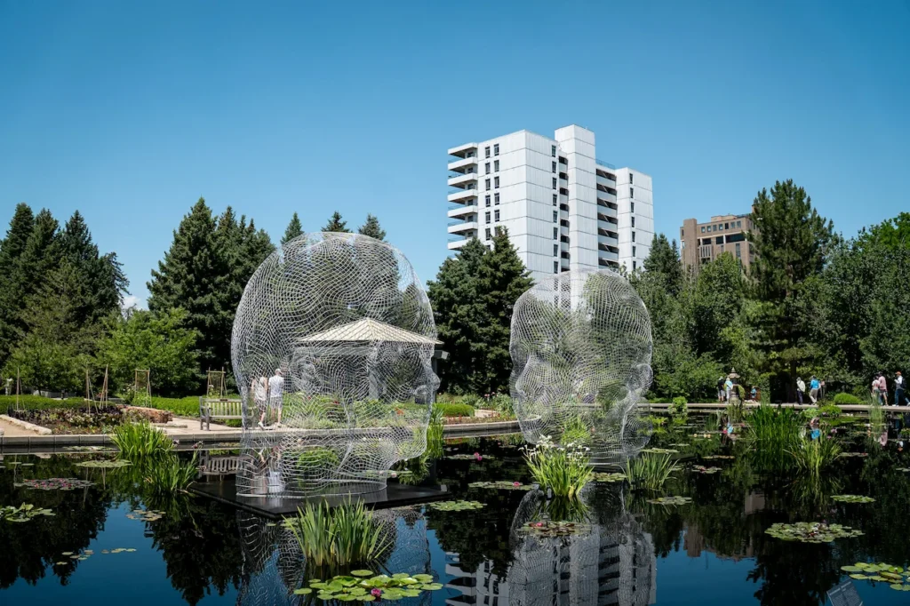 Jaume Plensa mesh face sculpture by a lily pad pond at Denver Botanic Gardens