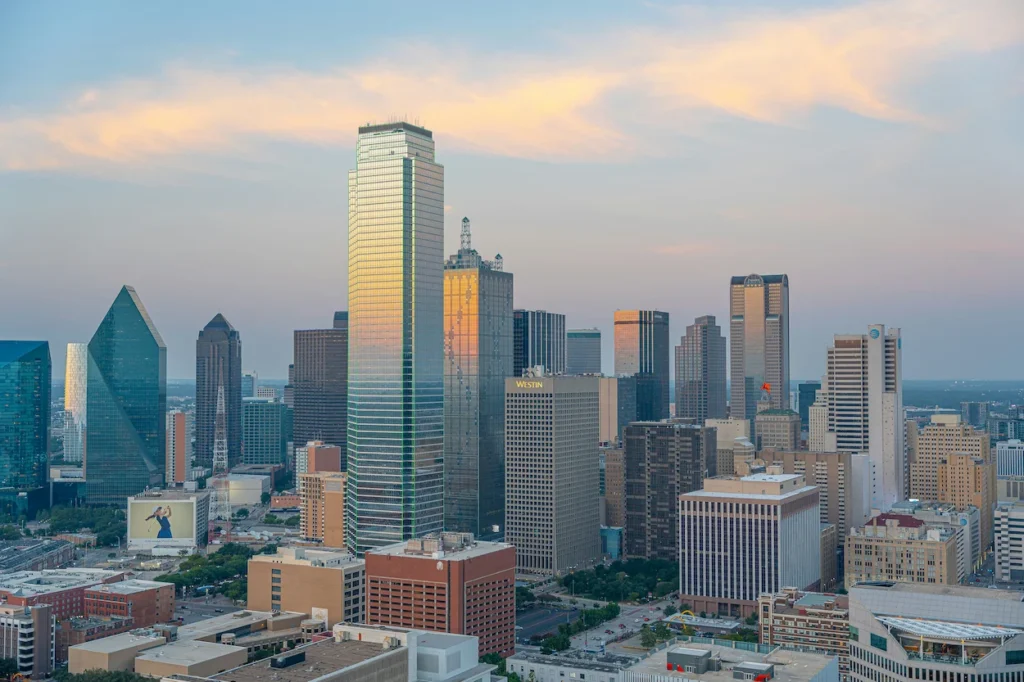 Downtown Dallas skyline illuminated by a vibrant orange and pink sunset sky