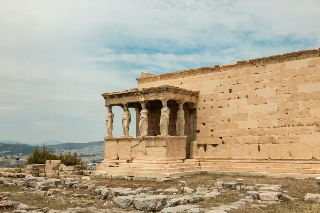 Ancient stone Caryatid female figure statues supporting the roof of a temple porch on the Acropolis