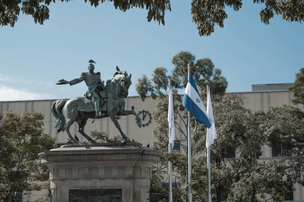 Bronze equestrian monument of Gerardo Barrios next to the waving El Salvador flag
