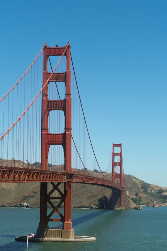 Golden Gate Bridge towers and suspension cables over the water under a clear blue sky