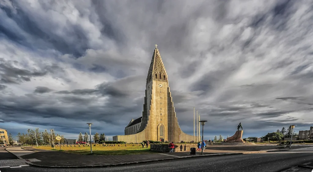 The tall, stepped concrete facade of Hallgrimskirkja church under a cloudy sky