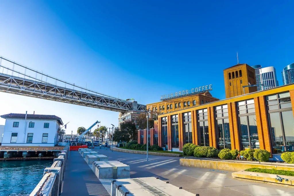 Hills Bros Coffee building and San Francisco-Oakland Bay Bridge seen from the waterfront boardwalk