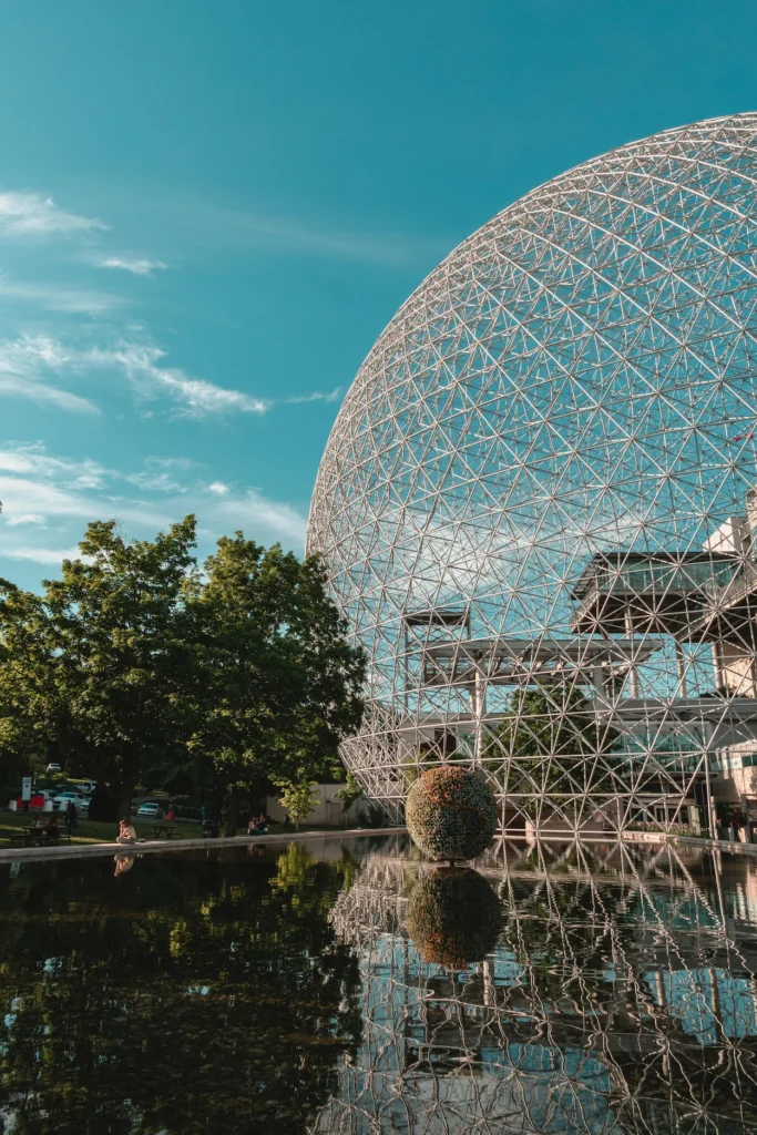 Massive steel geodesic dome structure of the Montreal Biosphere reflecting in a calm pond