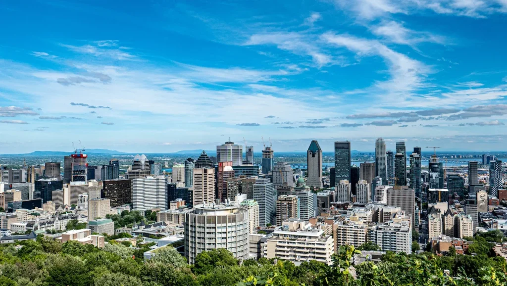 Montreal city skyline and skyscrapers viewed from the Mount Royal overlook under a blue sky