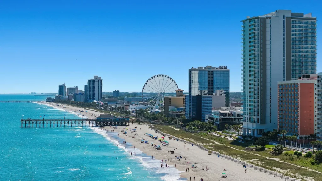 Myrtle Beach shoreline with high-rise hotels, the SkyWheel Ferris wheel, and a wooden fishing pier