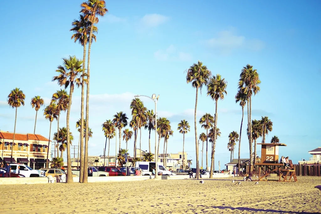 Sunny Newport Beach California sand with tall palm trees and wooden Lifeguard Tower 22