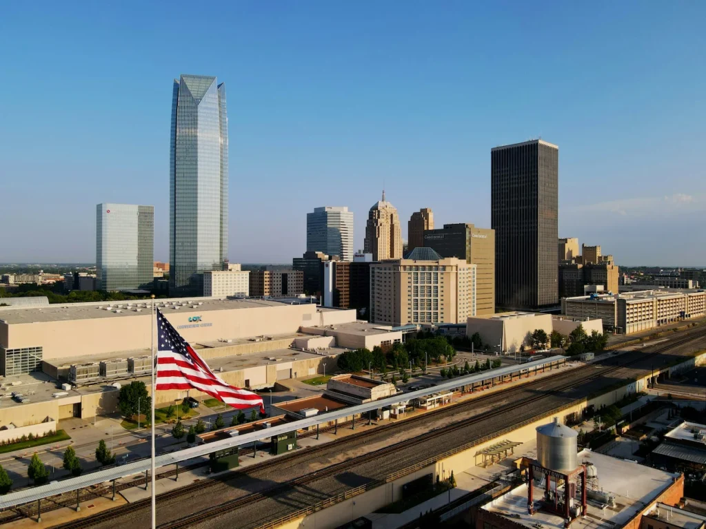 Oklahoma City skyline featuring Devon Tower and an American flag in the foreground