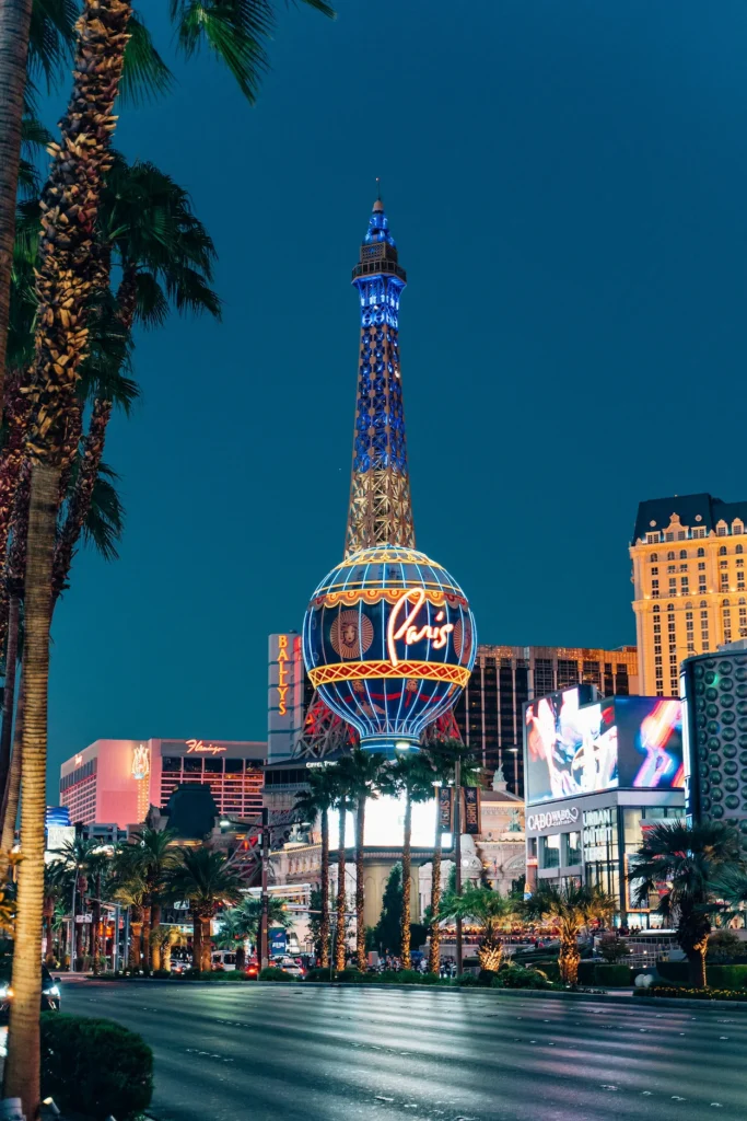 The illuminated Eiffel Tower replica and neon balloon sign at Paris Las Vegas at night