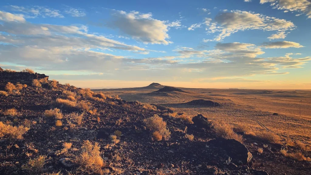 Rocky volcanic hills overlooking a desert plain at sunset in Albuquerque
