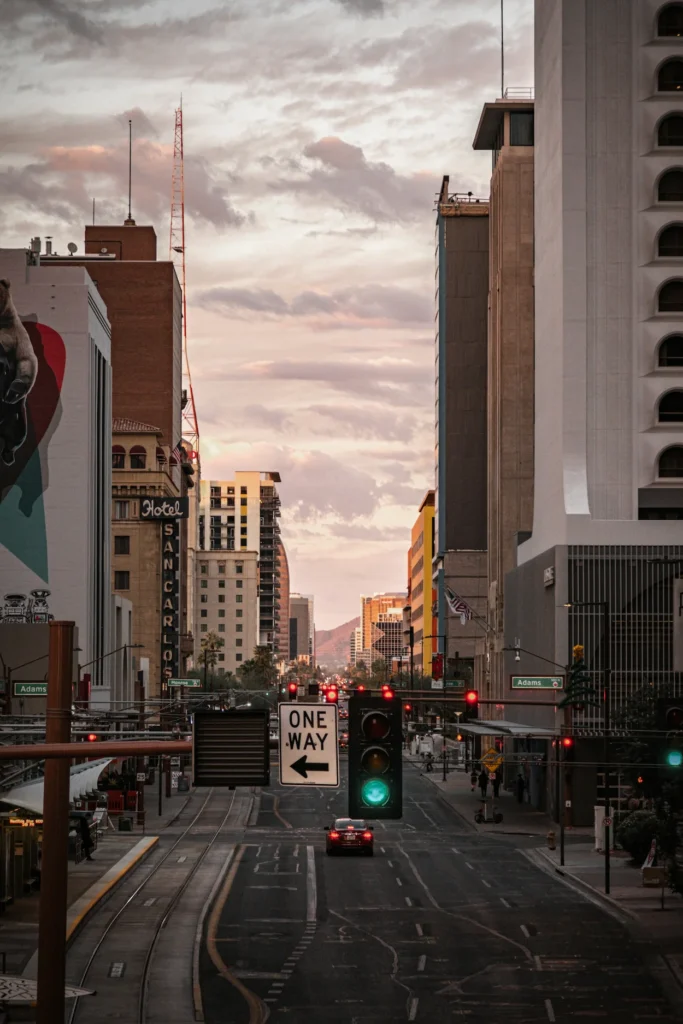 Downtown Phoenix street looking down Central Avenue toward mountains under a pastel sunset sky