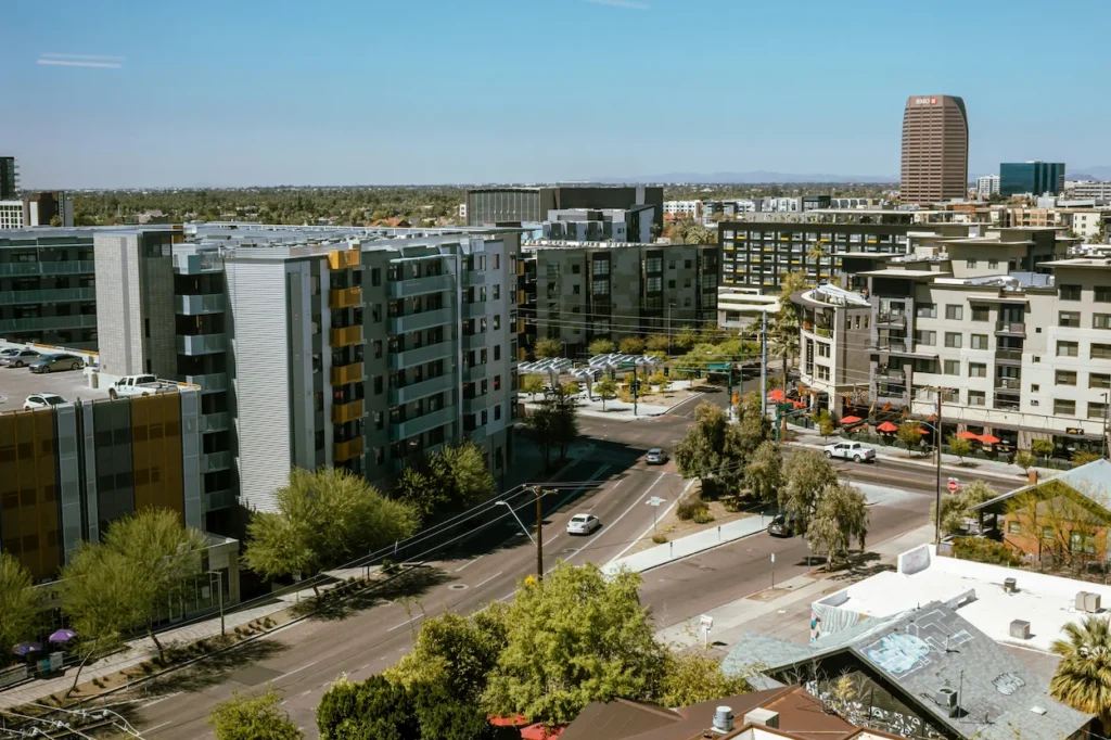 High-angle street view of modern apartment complexes and distant skyscrapers in Phoenix, Arizona