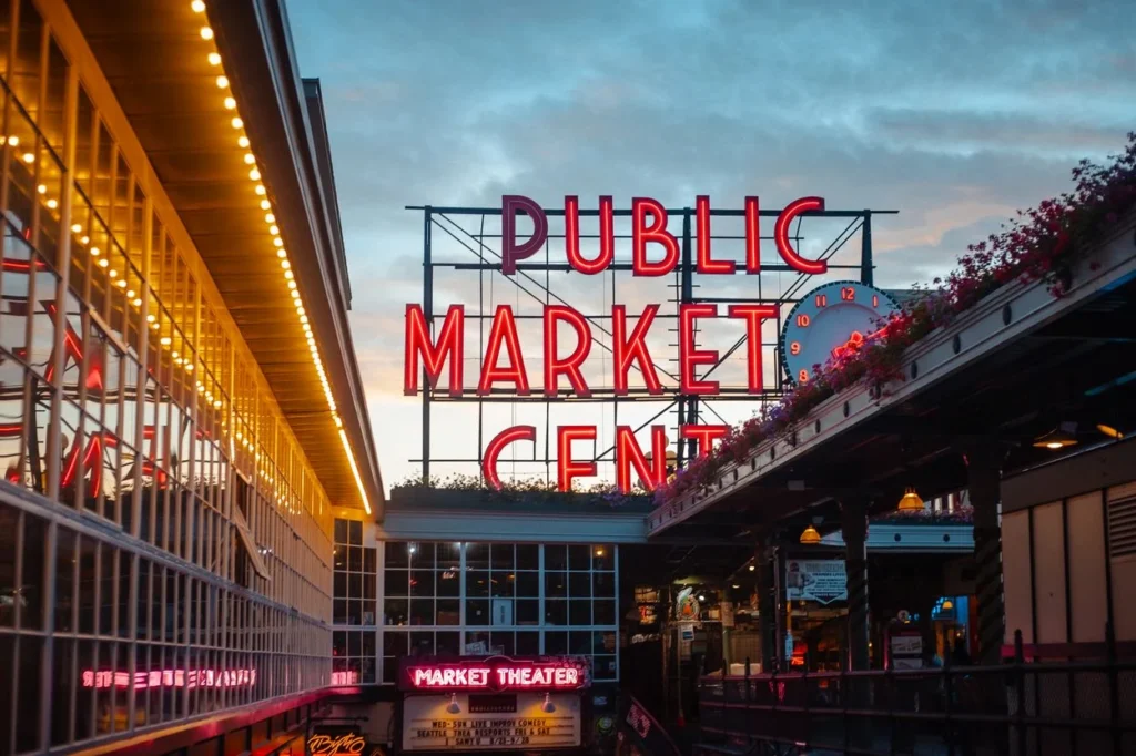Glowing red Public Market Center neon sign at dusk in Seattle