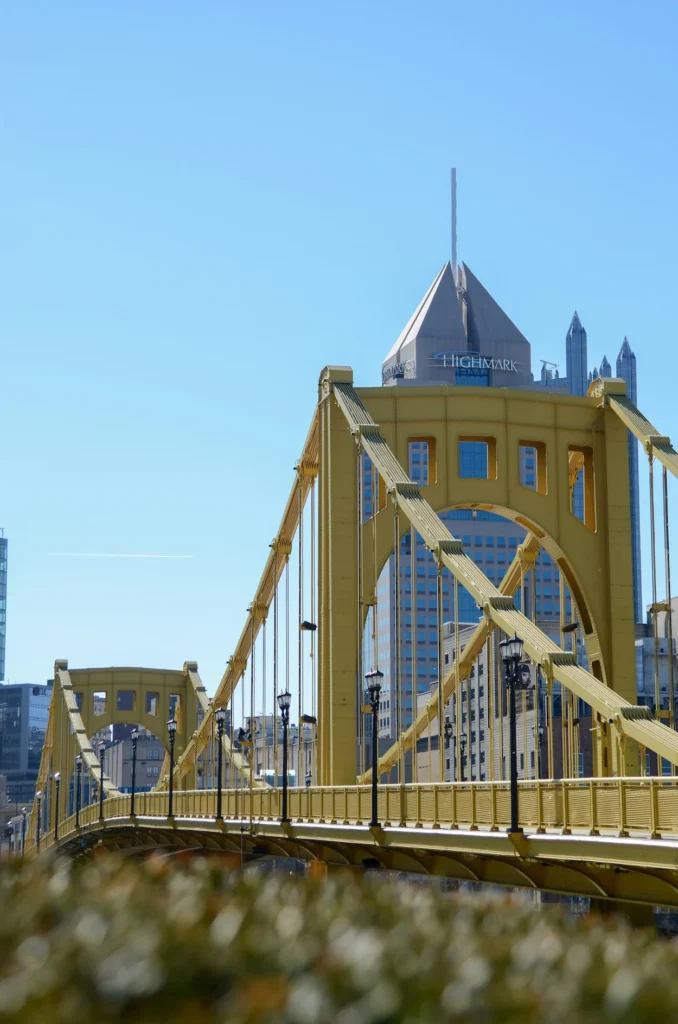 Yellow suspension bridge leading toward the Fifth Avenue Place tower in Pittsburgh