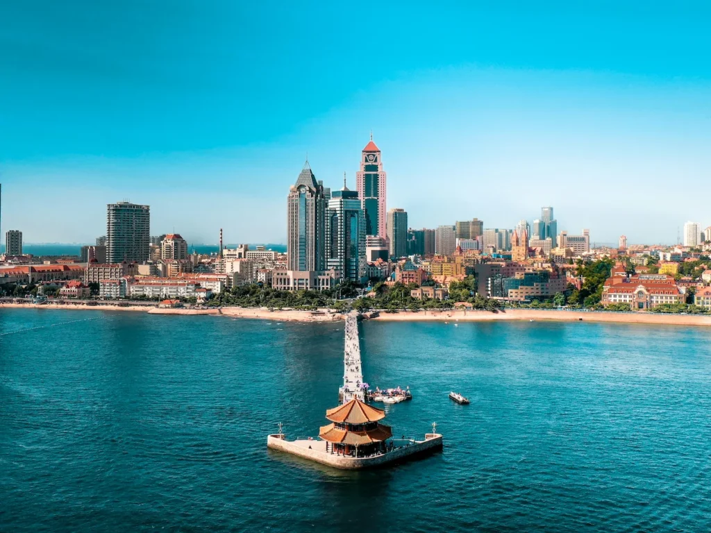 Qingdao Zhanqiao Pier and Huilan Pavilion extending into the blue ocean with the city skyline behind