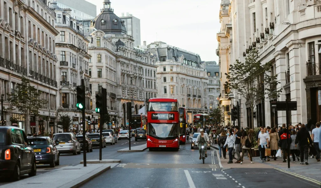 Busy London street scene on Regent Street with a red double-decker bus, cars, and pedestrians