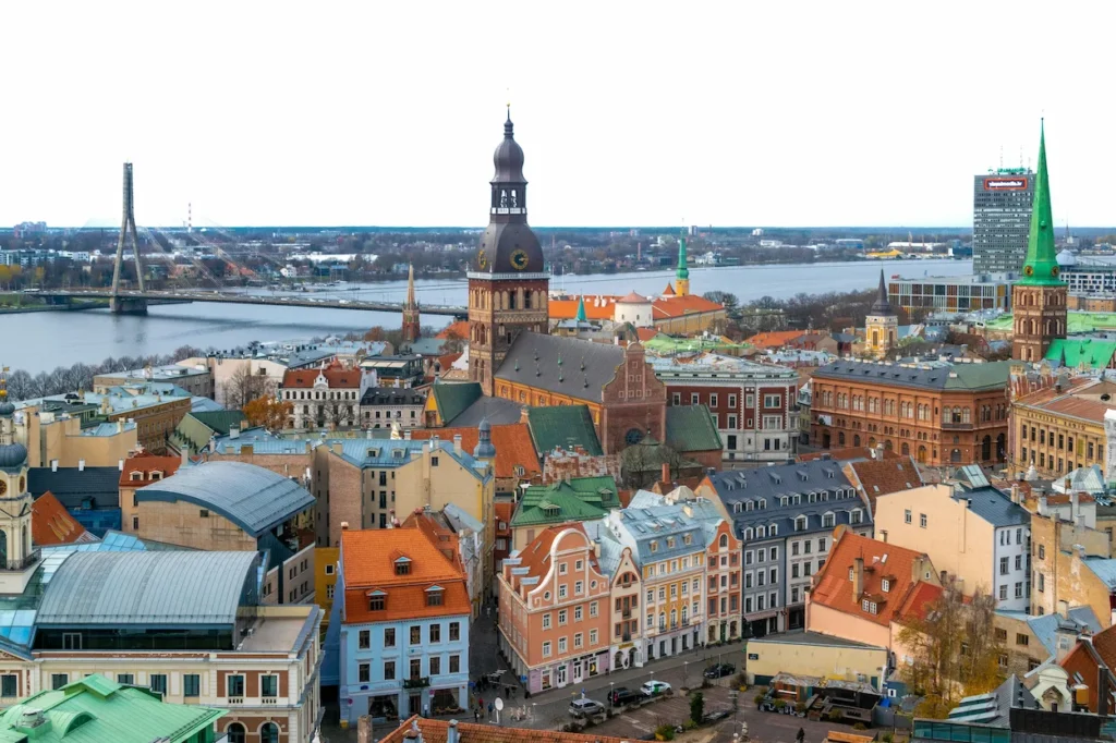 Elevated view of Riga Old Town buildings with orange roofs facing the Vanšu Bridge and Daugava River