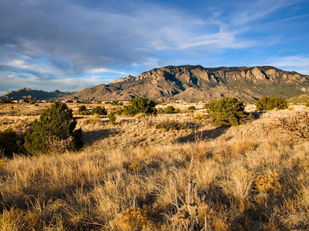 Sandia Mountains rocky peaks rising above dry desert brush foothills in Albuquerque, New Mexico