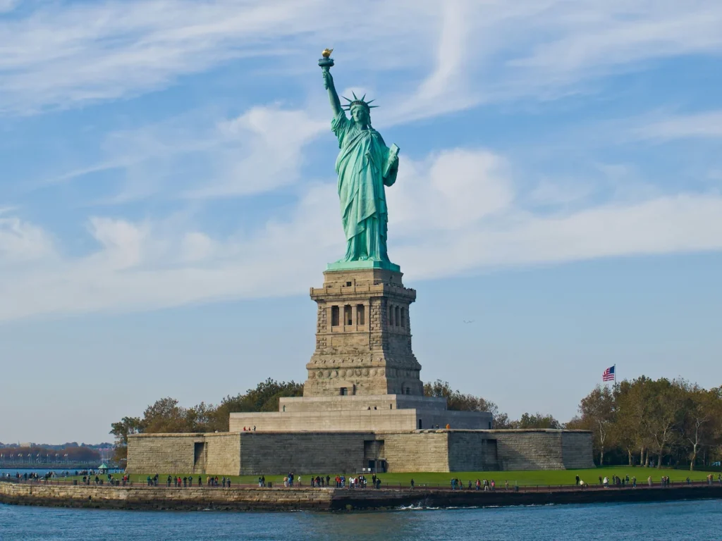 Statue of Liberty on its stone pedestal seen from the water on a clear day